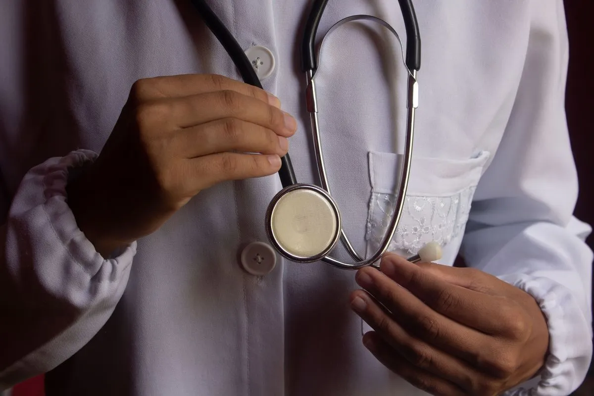 Clinician in a white coat holding a stethoscope